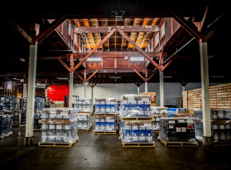 Industrial warehouse interior with neatly stacked pallets of drums